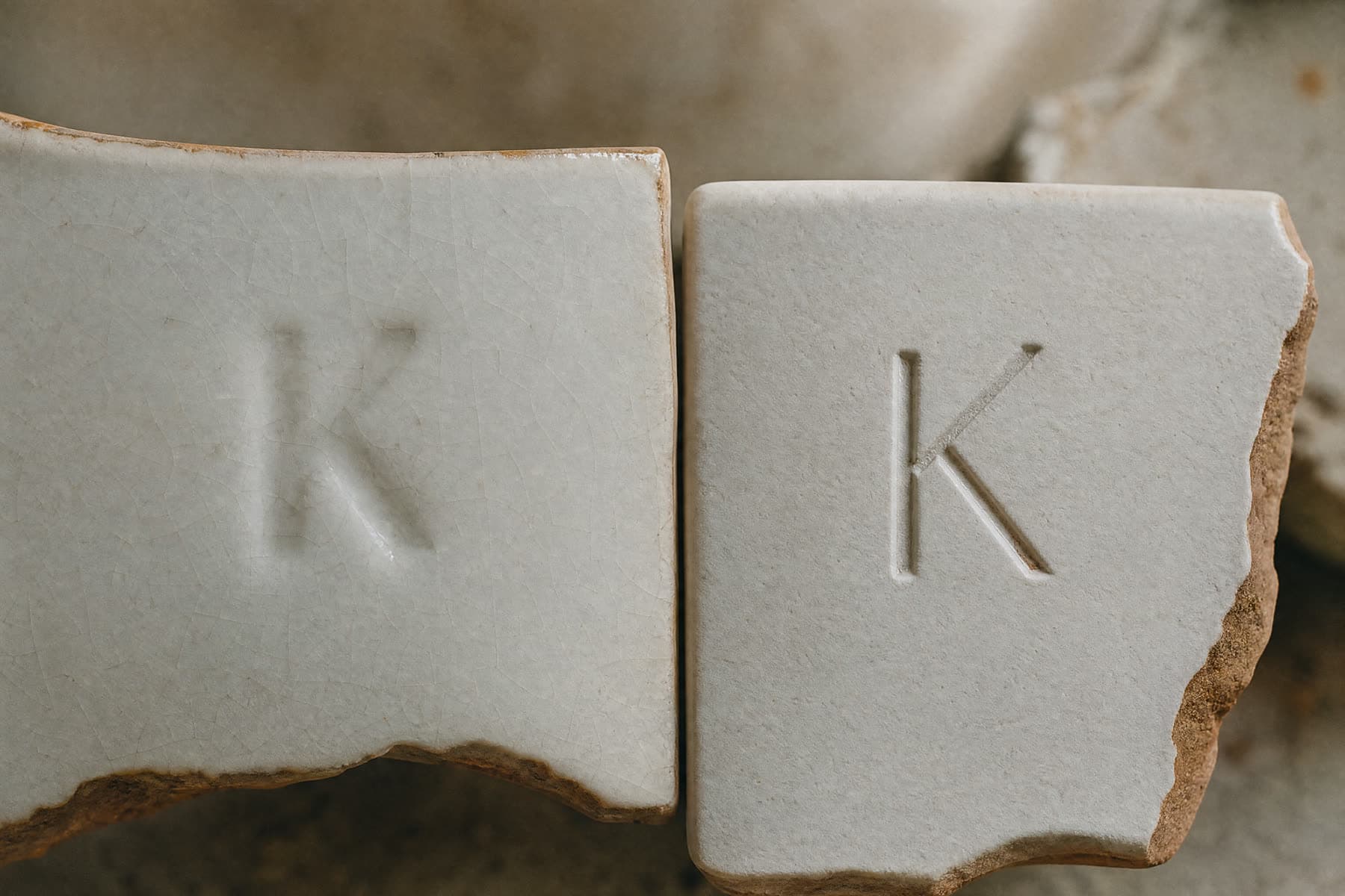 Two porcelain fragments side by side carrying the same letter made by two different methods